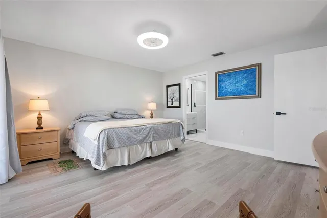 a spacious bedroom with a bed and a lamp