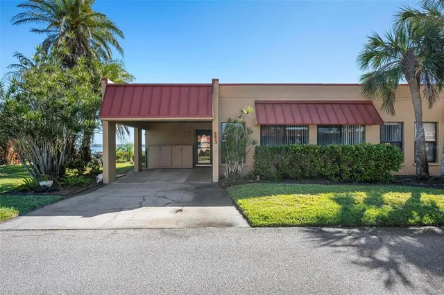 a view of a house with a yard and palm trees