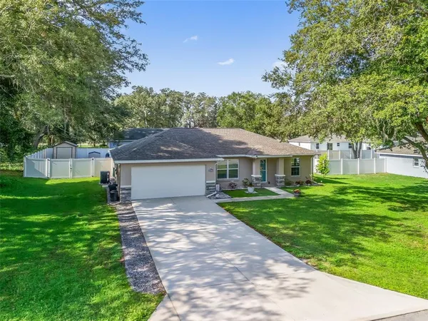 a front view of a house with yard patio and green space