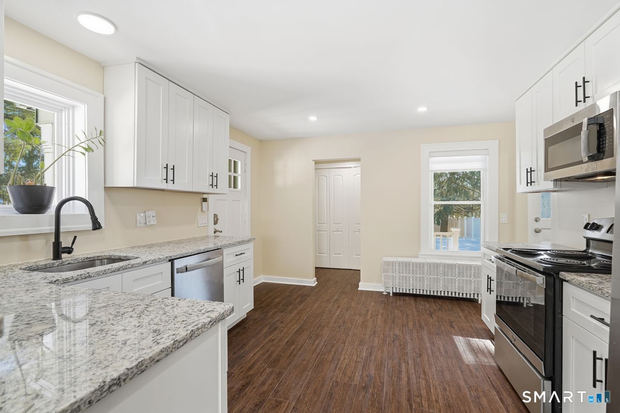 206 Gale Avenue Meriden, CT 06450 - Photo 13 of 33 a kitchen with stainless steel appliances granite countertop a sink stove and wooden cabinets
