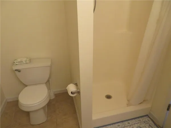 a bathroom with a toilet and a shower