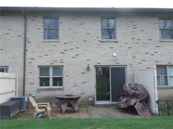 a brick house with a table and chairs in front of it