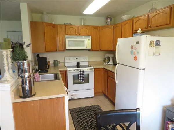 a kitchen with a refrigerator a stove a sink dishwasher and white cabinets with wooden floor
