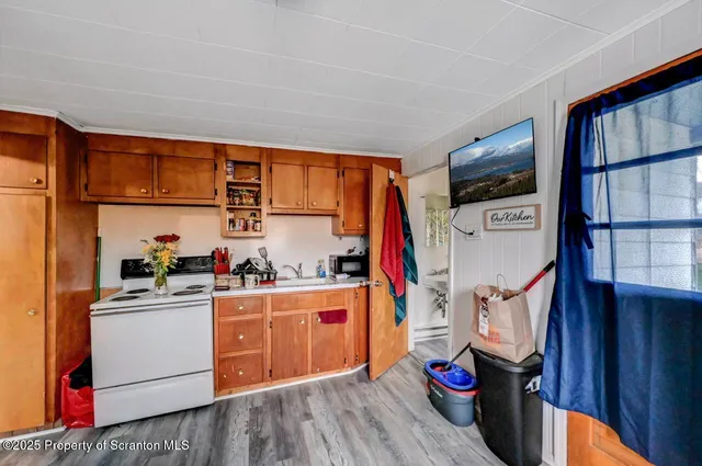 a kitchen with stainless steel appliances a stove and a wooden floor