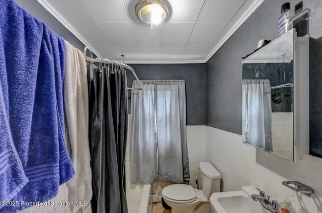 a bathroom with a toilet a sink and shower