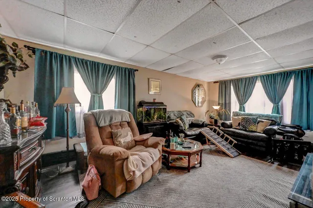 a living room with furniture a large window and a flat screen tv