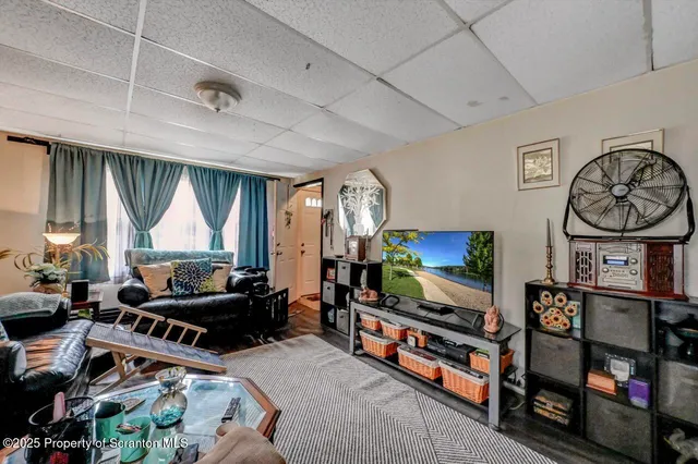 a living room with furniture a flat screen tv and a window