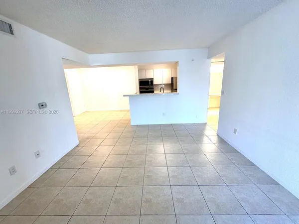a view of a kitchen with an empty space and a window