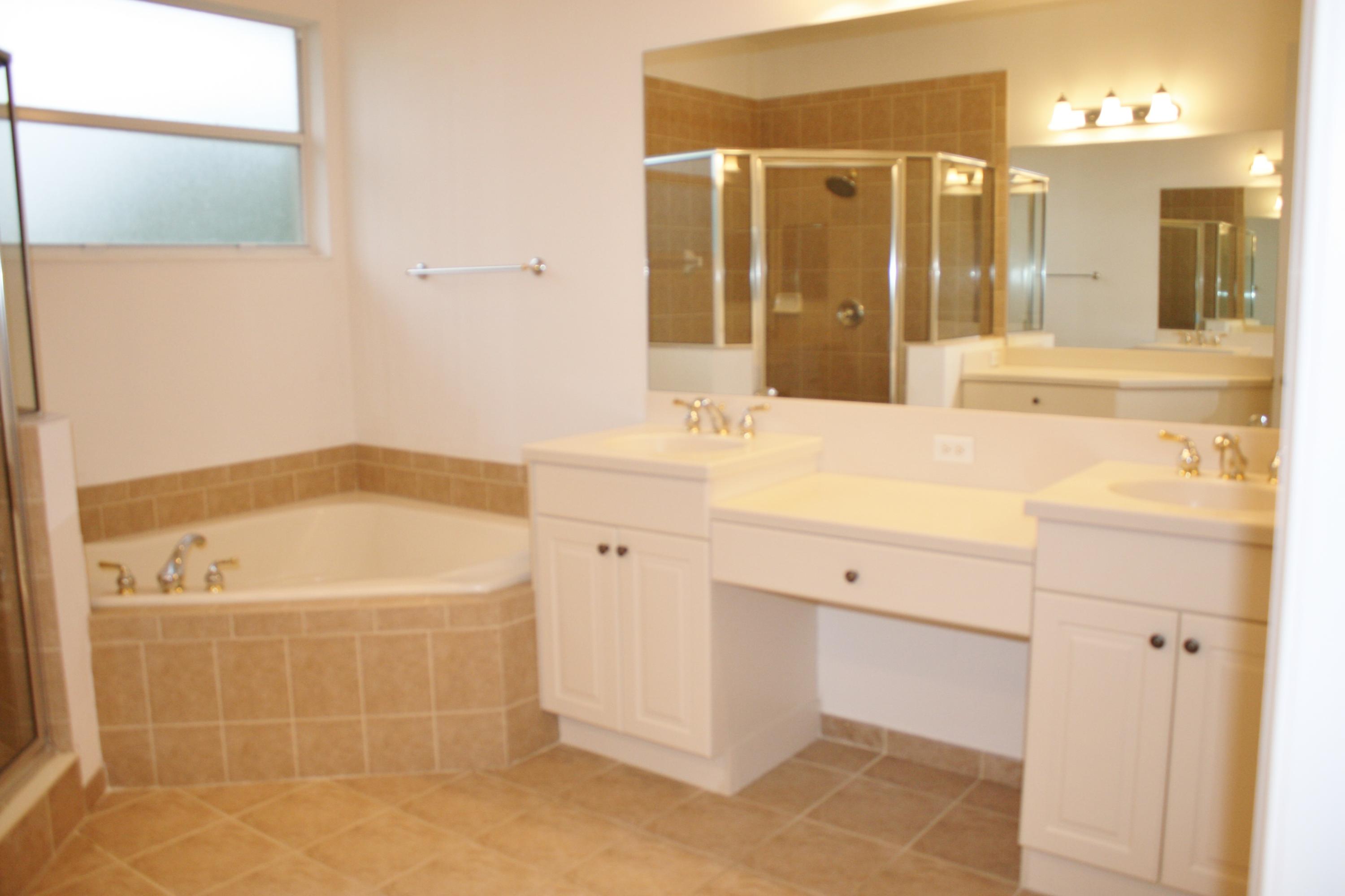 334 Southwest Walking Path, Unit 334 Stuart, FL 34997 - Photo 22 of 34 a bathroom with a tub sink and mirror