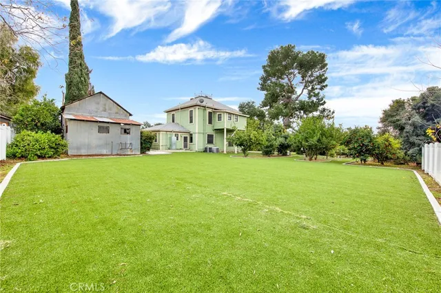 an aerial view of residential houses with outdoor space and trees