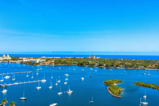 a large kitchen with kitchen island a large counter top a stove a chimney a sink and cabinets