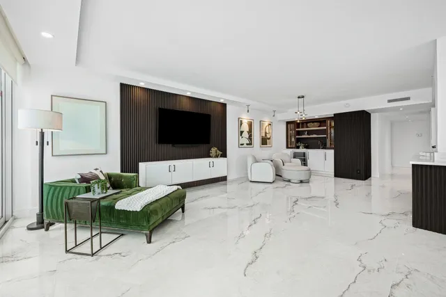 a living room with furniture a bed and kitchen view
