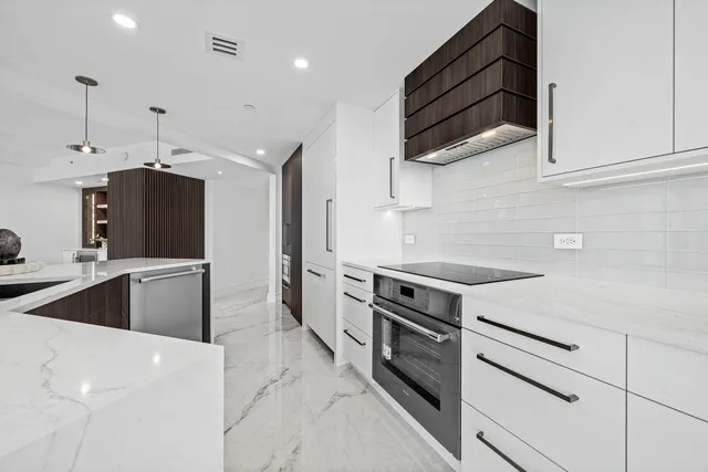 a kitchen with stainless steel appliances kitchen island granite countertop a refrigerator and a stove top oven