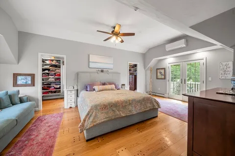 a bedroom with a large bed a couch and a window