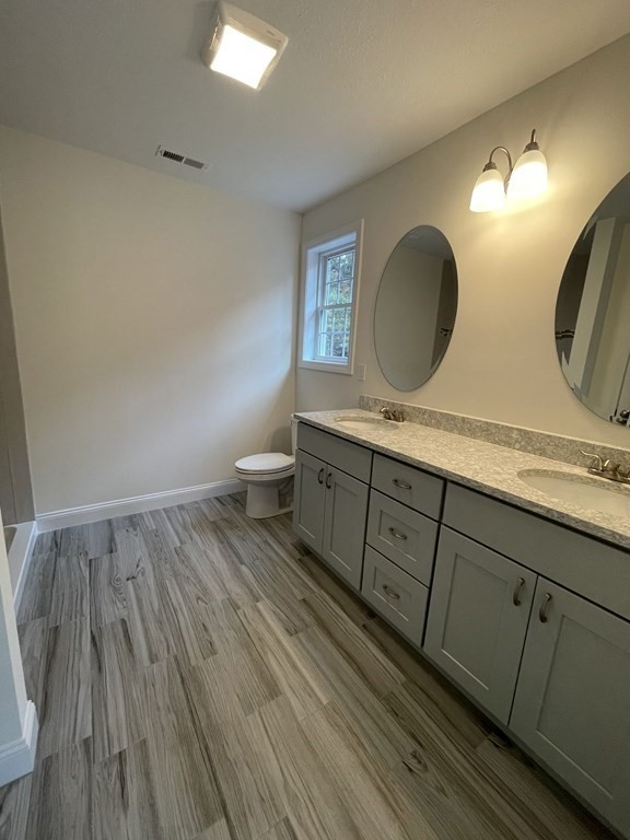 12 Hayfield Road, Unit 1 Dracut, MA 01826 - Photo 24 of 32 a bathroom with a double vanity sink and a mirror