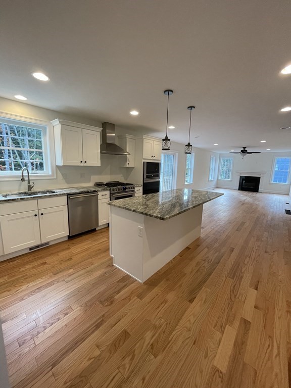 12 Hayfield Road, Unit 1 Dracut, MA 01826 - Photo 8 of 32 a large kitchen with stainless steel appliances granite countertop a stove and a wooden floors