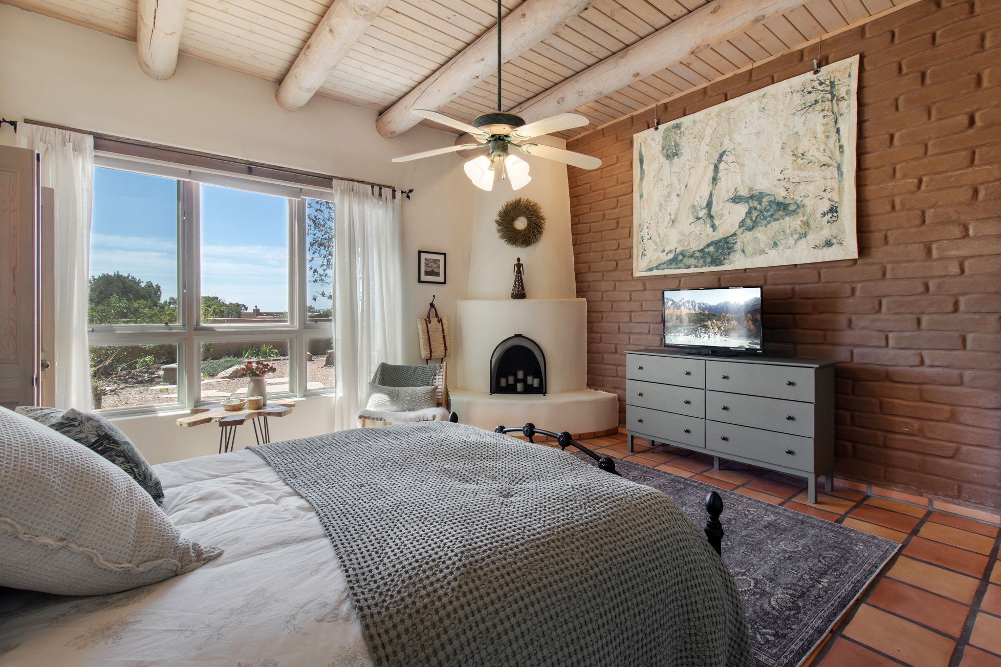 23 Monterey Road Santa Fe, NM 87508 - Photo 19 of 41 Exposed adobe wall in primary suite, kiva fireplace, large windows
