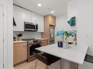 a kitchen with a stove a sink a microwave a dining table and chairs