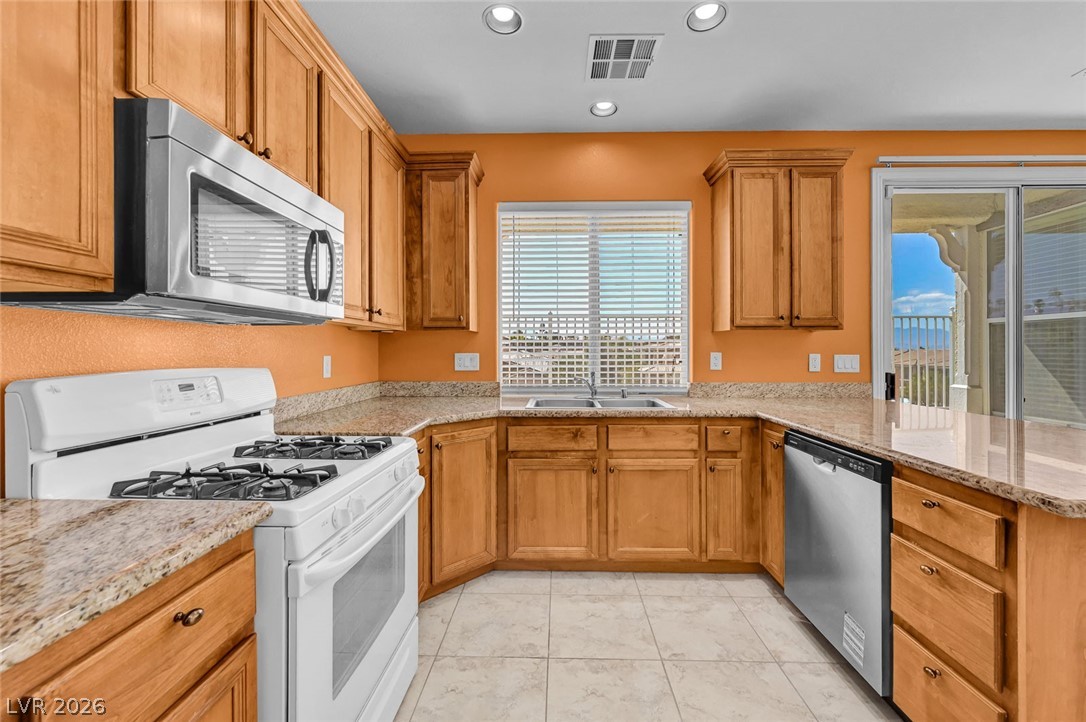 977 Sparkling Light Street Henderson, NV 89052 - Photo 32 of 75 This spacious kitchen offers ample cabinetry, modern appliances, and a beautiful view from the window.