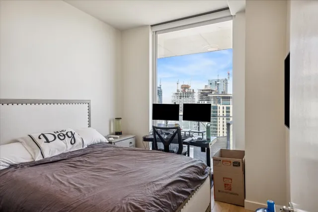 a bedroom with a bed and a flat tv screen on the dresser
