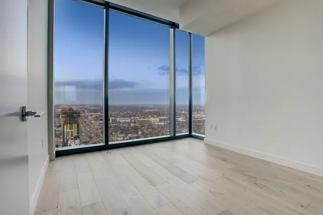 a view of a room with wooden floor and large window