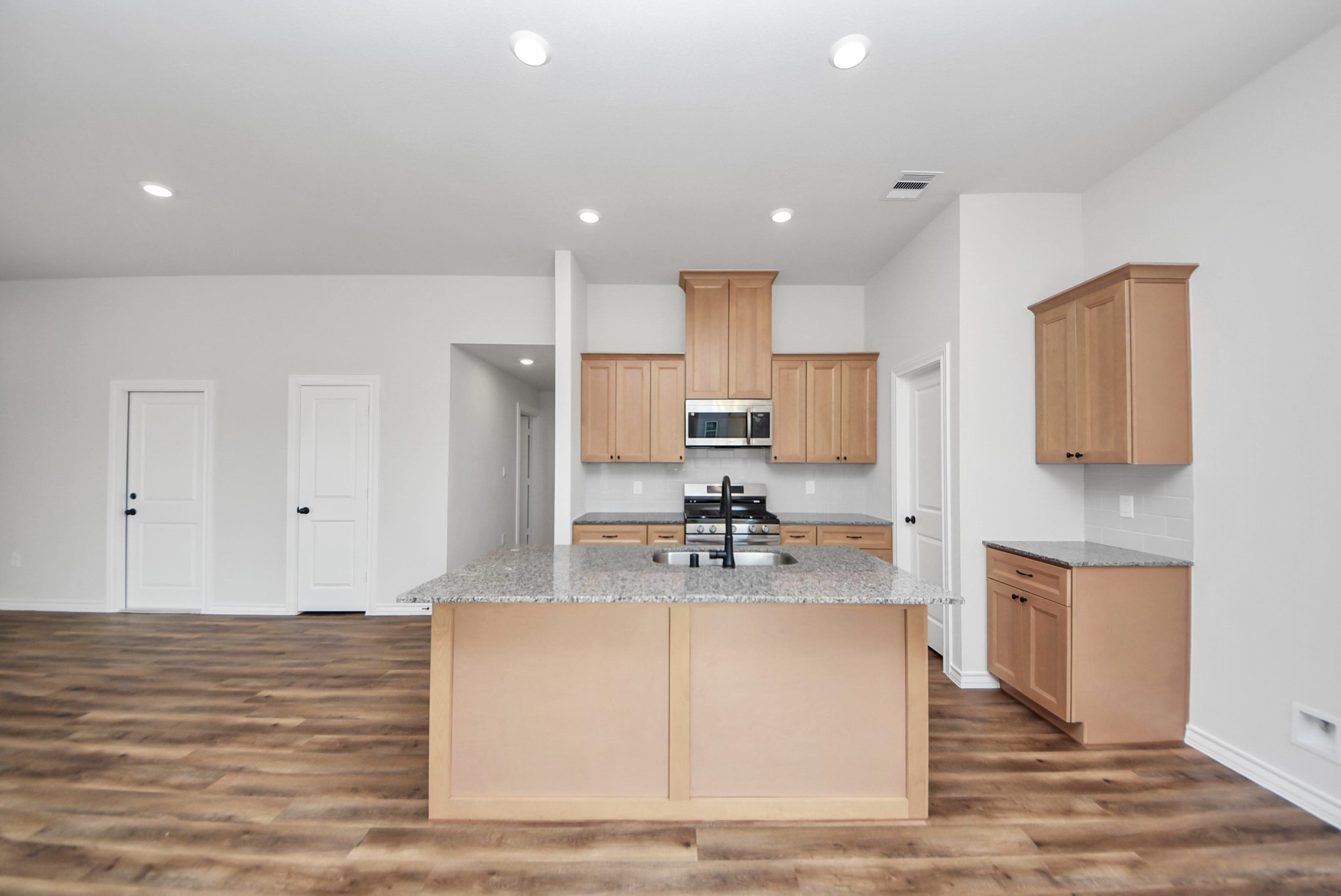 25740 John Wayne Drive Splendora, TX 77372 - Photo 15 of 48 a large kitchen with kitchen island a sink stainless steel appliances and cabinets