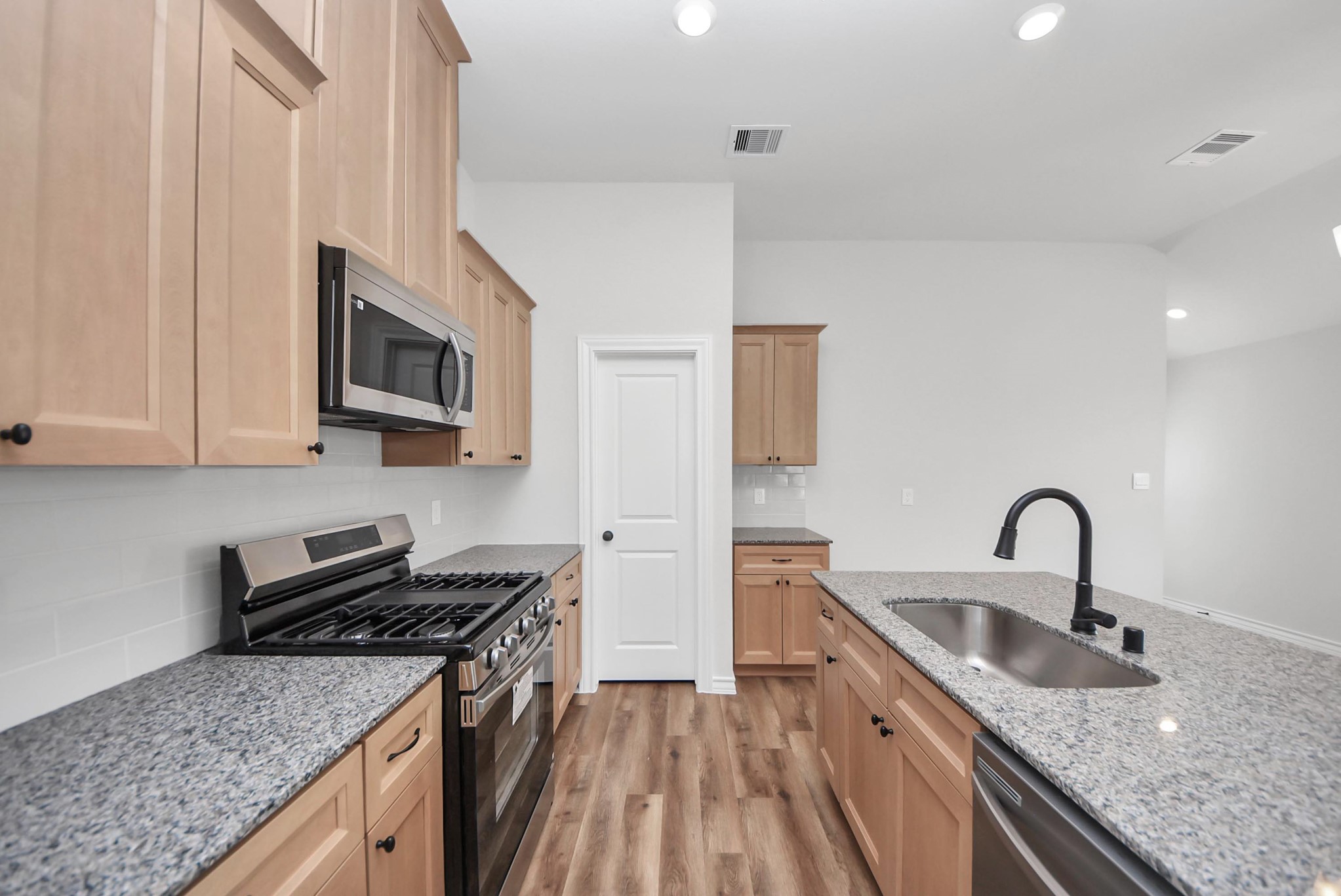 25740 John Wayne Drive Splendora, TX 77372 - Photo 20 of 48 a kitchen with granite countertop a sink a stove and cabinets