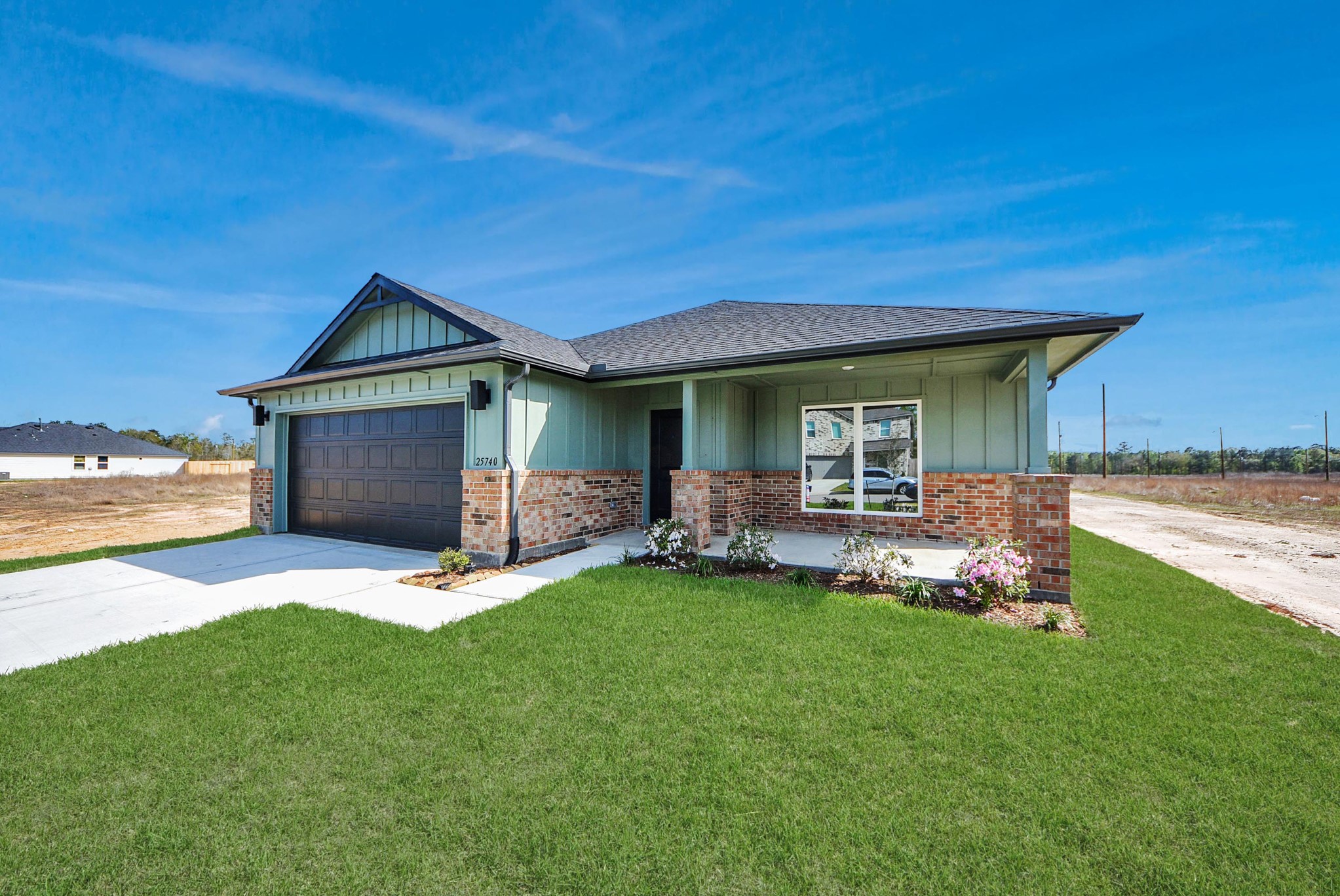 25740 John Wayne Drive Splendora, TX 77372 - Photo 2 of 48 a front view of a house with a garden and yard