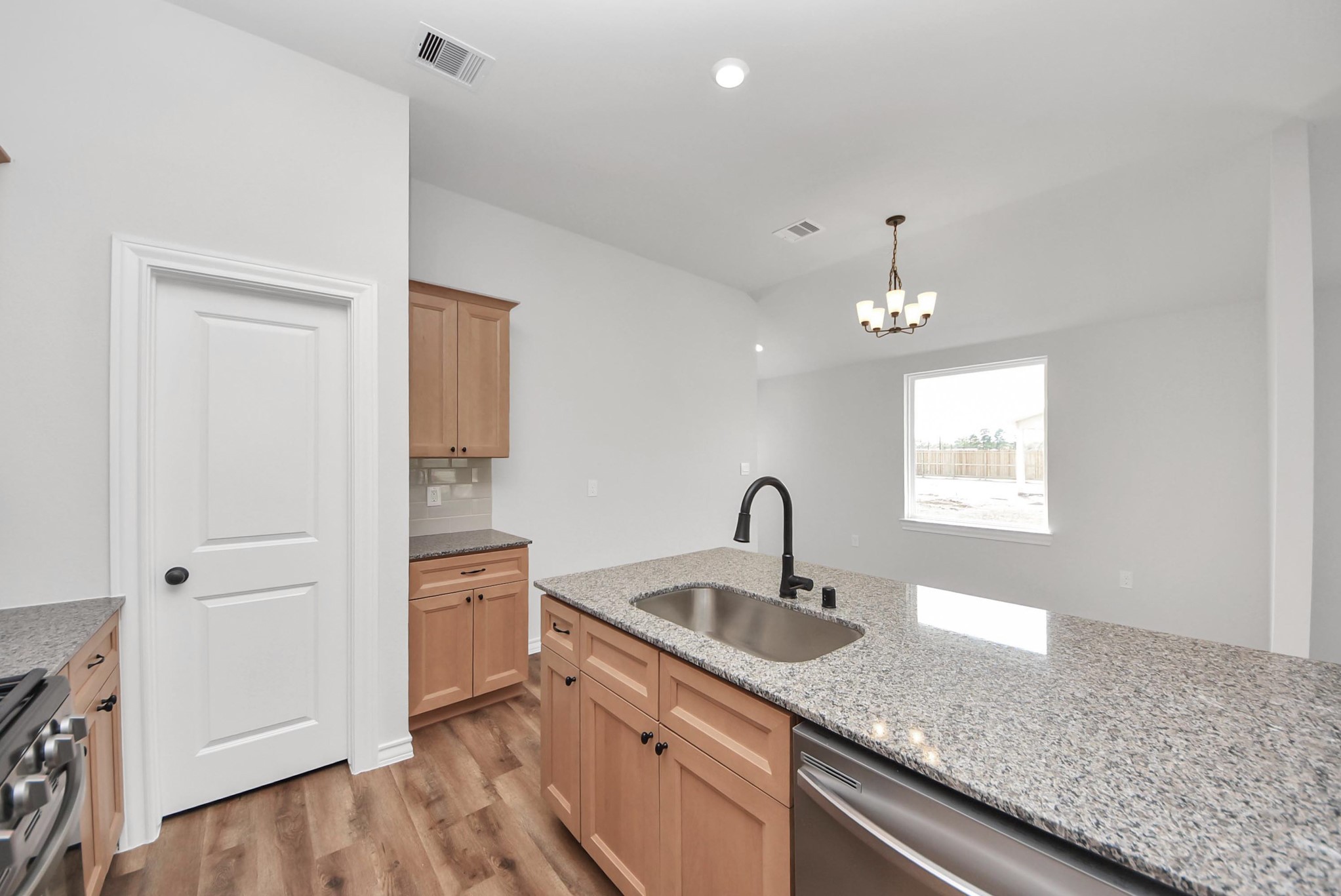 25740 John Wayne Drive Splendora, TX 77372 - Photo 21 of 48 a kitchen with a sink and chandelier