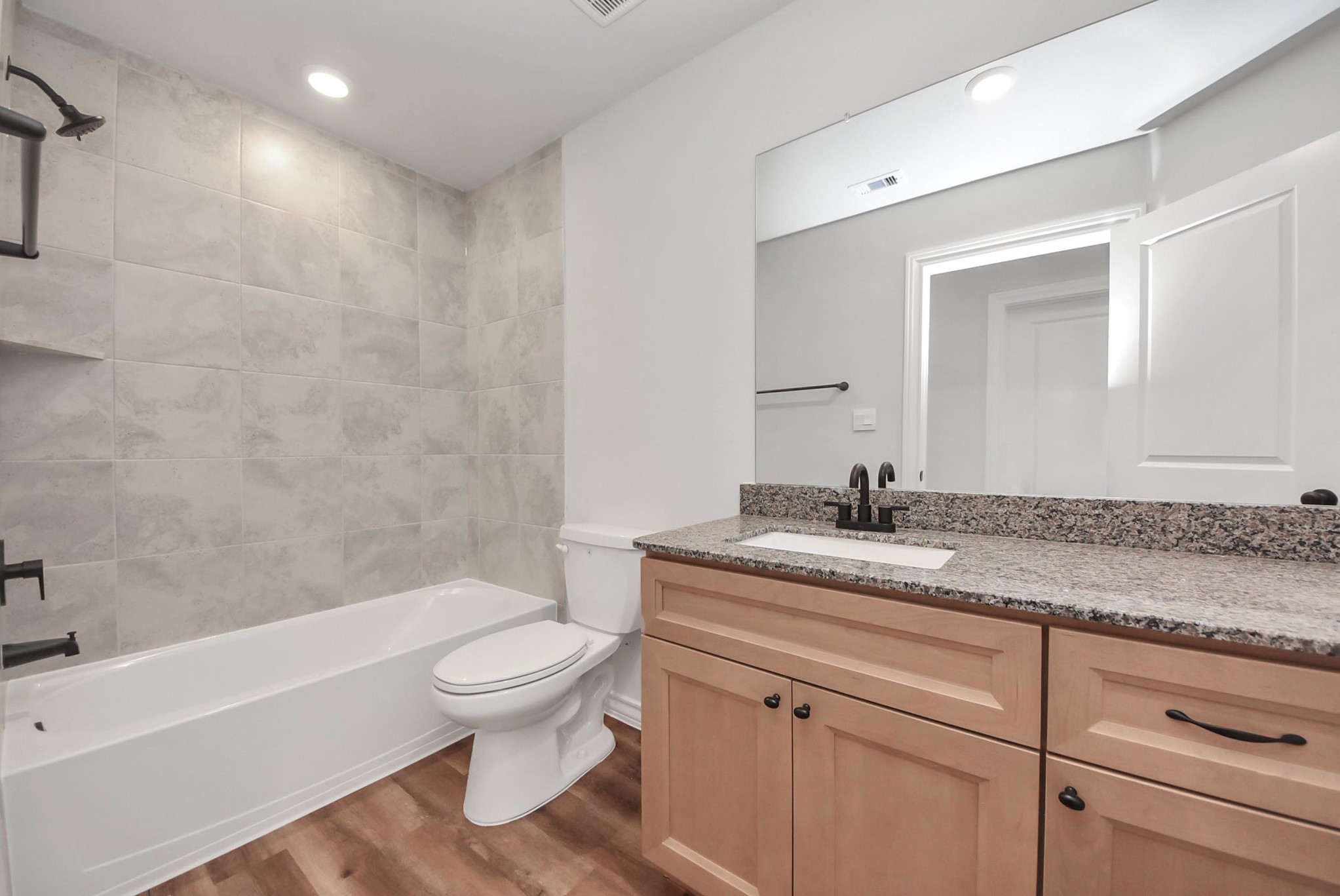 25740 John Wayne Drive Splendora, TX 77372 - Photo 42 of 48 a bathroom with a granite countertop sink a toilet and a bathtub