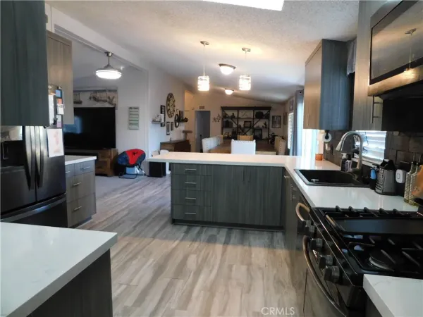 a kitchen with stainless steel appliances a sink a stove top oven a counter space and cabinets