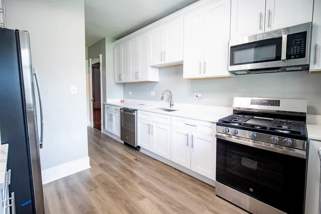 a kitchen with stainless steel appliances a stove microwave and sink