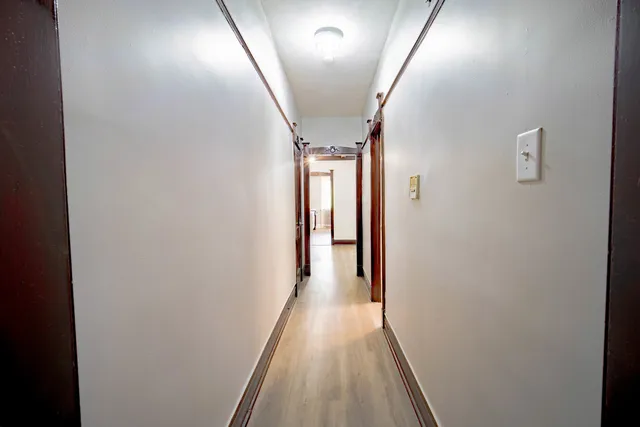 a view of a hallway with wooden floor and staircase