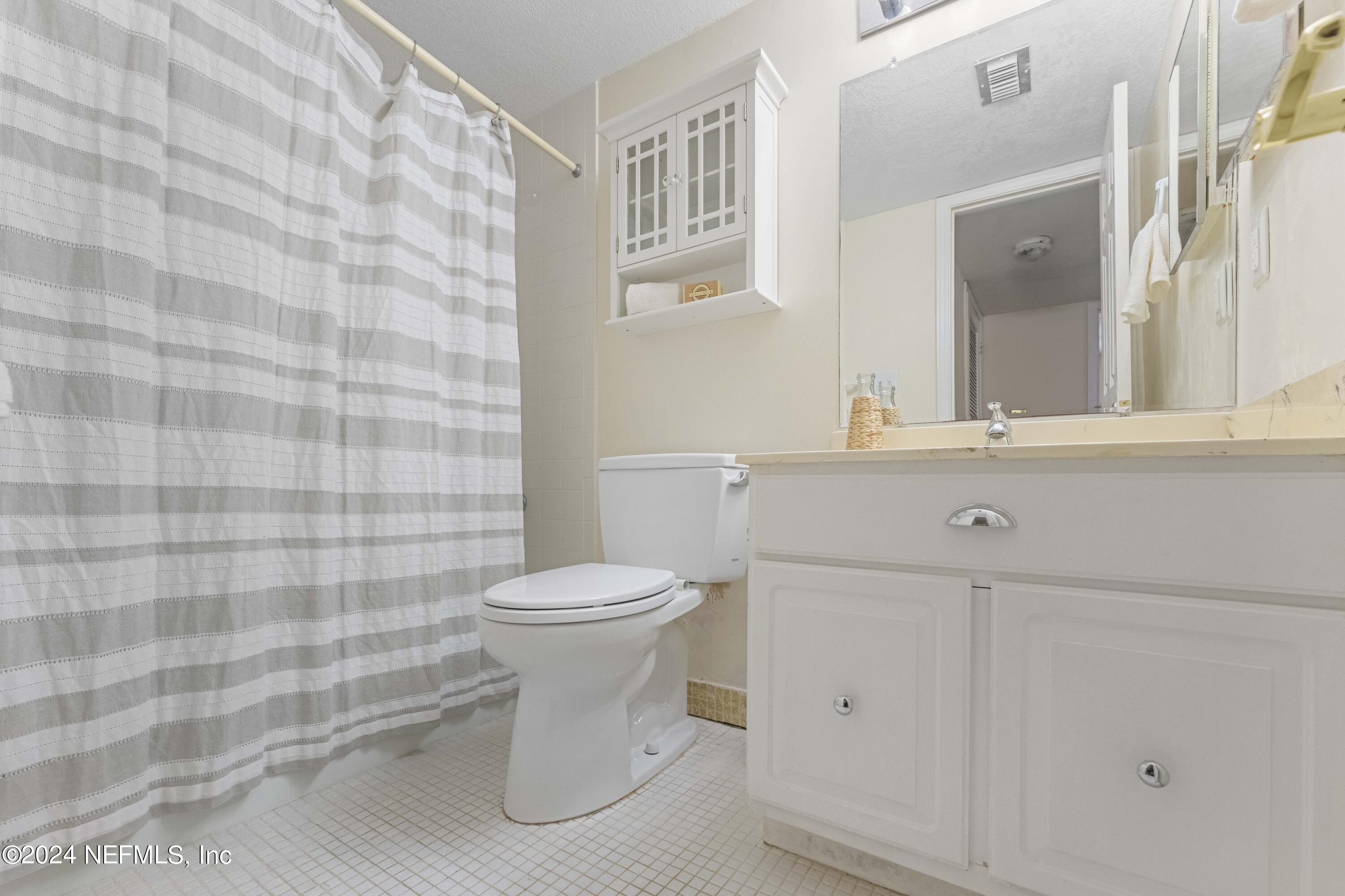 10 10th Street, Unit 17 Atlantic Beach, FL 32233 - Photo 26 of 60 a bathroom with a sink a toilet and mirror