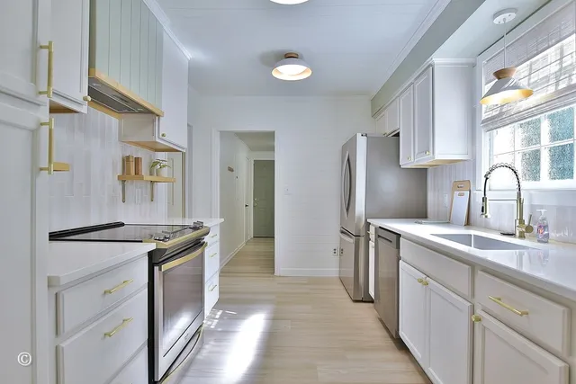 a kitchen with stainless steel appliances granite countertop a sink stove and refrigerator