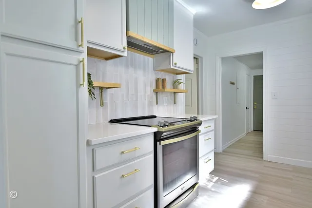 a kitchen with stainless steel appliances granite countertop a stove and a refrigerator