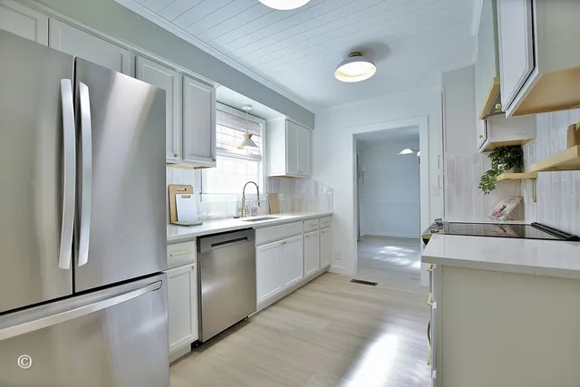 a kitchen with stainless steel appliances granite countertop a refrigerator and a sink