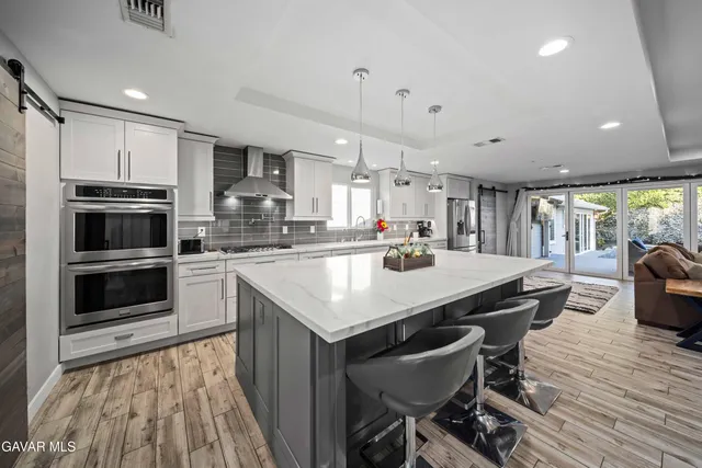 a kitchen with kitchen island a stove a table and chairs in it