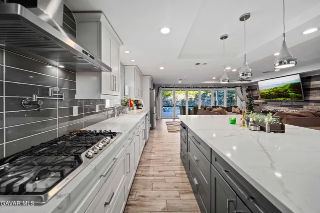 a large kitchen with kitchen island a sink stainless steel appliances and cabinets