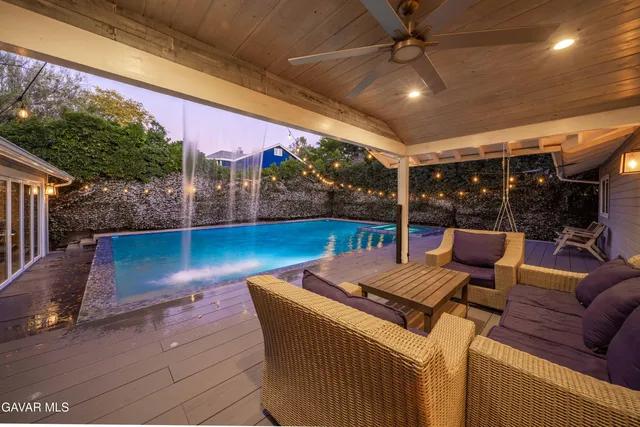 a living room with furniture kitchen view and a large window