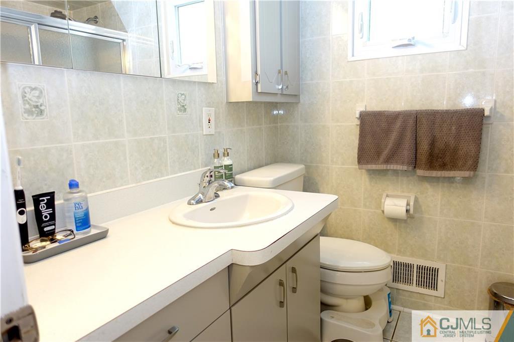 194 McFarlane Road Colonia, NJ 07067 - Photo 16 of 16 a bathroom with a sink a toilet and mirror