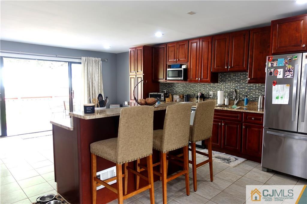 194 McFarlane Road Colonia, NJ 07067 - Photo 5 of 16 a kitchen with a refrigerator a stove a sink dishwasher with a dining table and chairs
