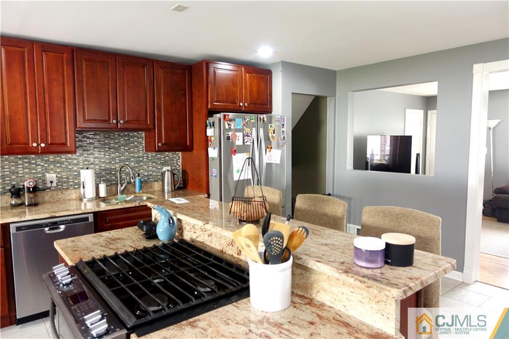 194 McFarlane Road Colonia, NJ 07067 - Photo 7 of 16 a kitchen with stainless steel appliances granite countertop a stove top oven a sink and dishwasher