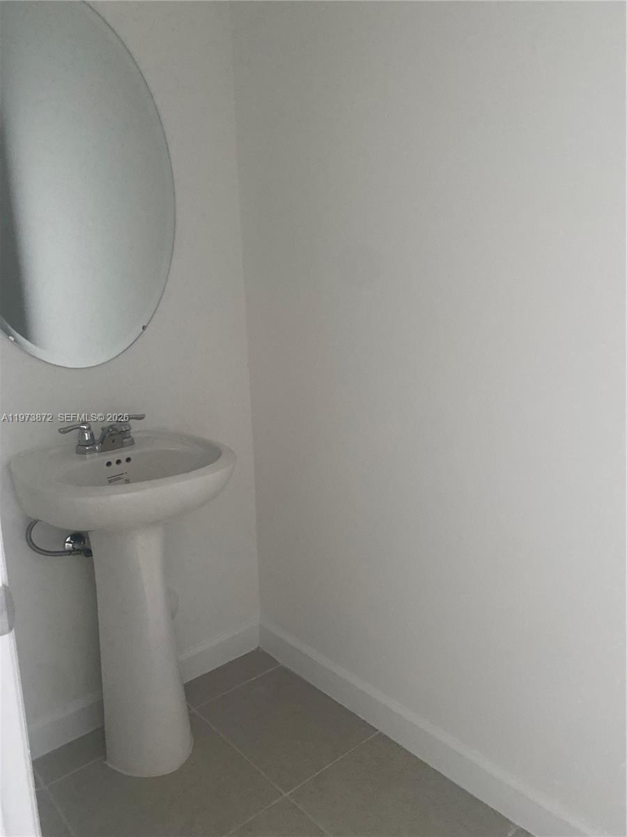 27559 Southwest 159th Place Homestead, FL 33033 - Photo 10 of 14 a bathroom with a sink a mirror and vanity