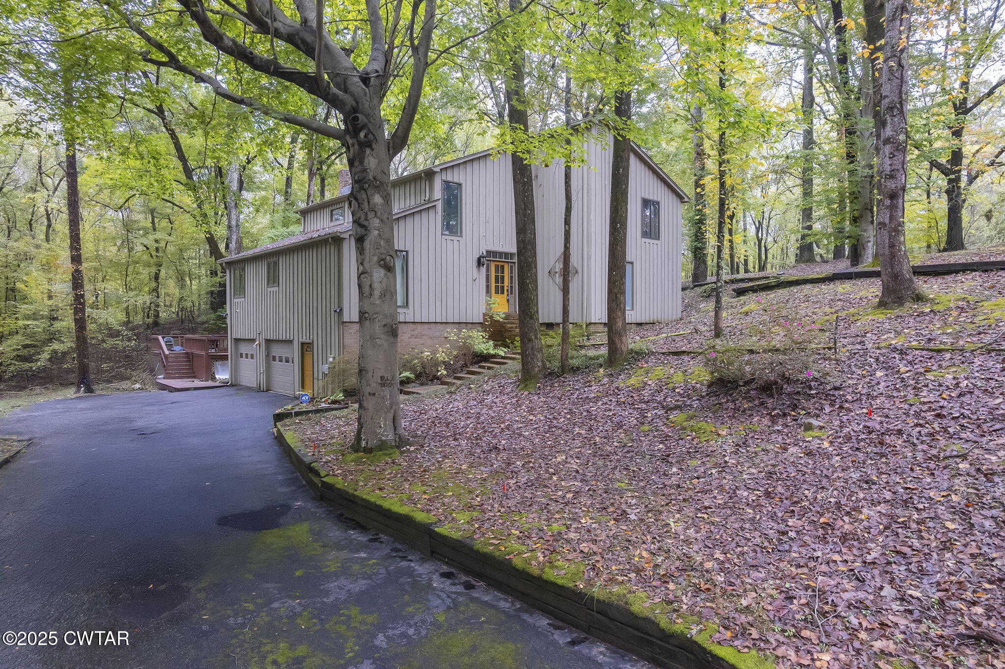a view of a house with backyard and trees