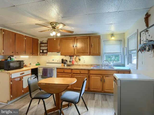 a kitchen with cabinets a sink and chairs