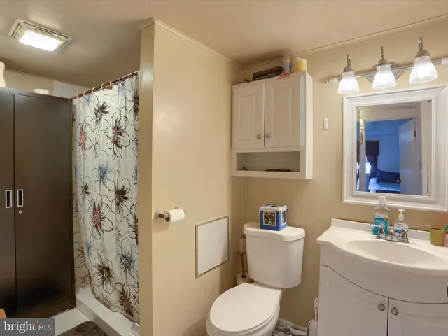 a bathroom with a sink toilet vanity and shower