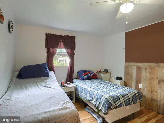 a bedroom with two beds and painting on the wall