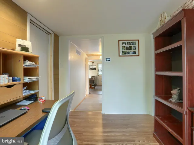 a view of a workspace with furniture and wooden floor
