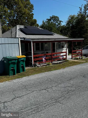 a view of house with outdoor space and parking area